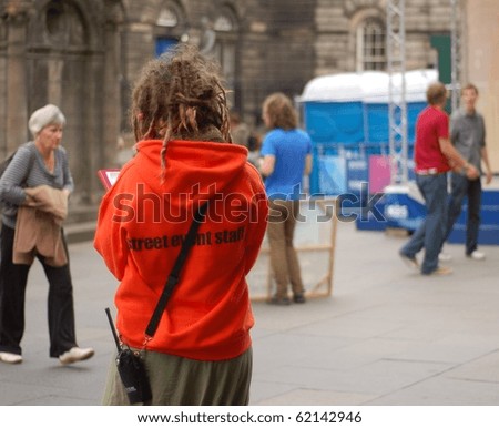 EDINBURGH - AUGUST 28: A member of staff involved in Edinburgh\'s Fringe Festival stands on the Royal Mile on August 28th, 2010 in Edinburgh, UK. The arts Festival is one of the largest in the world.