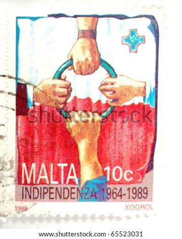 MALTA - CIRCA 1989: a stamp printed in Malta shows the four hands holding a ring in front of the Maltese flag and celebrates 25 years of Maltese independence, circa 1989
