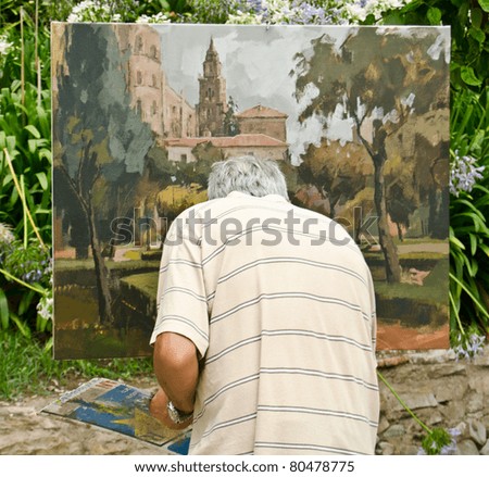 MALAGA, SPAIN - JUNE 25: a man paints on canvas on June 25, 2011 in Malaga, Spain. Birthplace of Picasso, Malaga is a city in which it is common to find artists painting in the streets and parks.