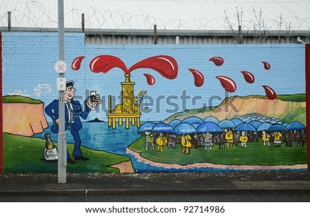 BELFAST, NORTHERN IRELAND - DECEMBER 31: a mural criticises human rights violations for oil spoils on December 31, 2011 on the Falls Road in Belfast, Northern Ireland.