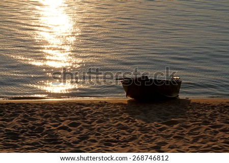 boat on a sunset, boat on a riverbank at sunset, rowing boat on a lake at sunset, Romantic lonely boat at sunset
