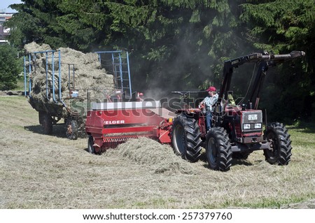 FRANKFURT,GERMANY-JUNE 17:woman drives a tractor in hay field on June 17,2013 in Frankfurt,Germany.