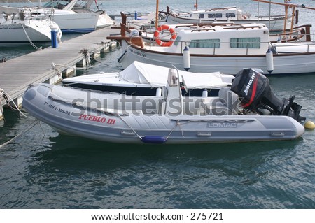 inflatable boat with outboard motor alongside other leasure boats