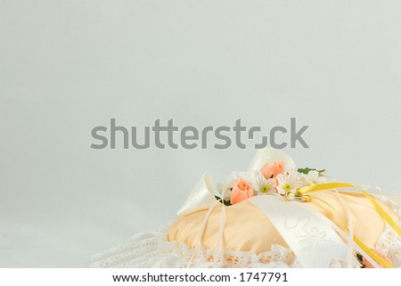 stock photo wedding ring on a cushion with flowers and ribbons