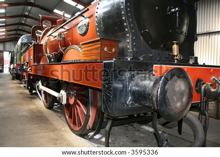 steam train in a train shed with a wooden box on board
