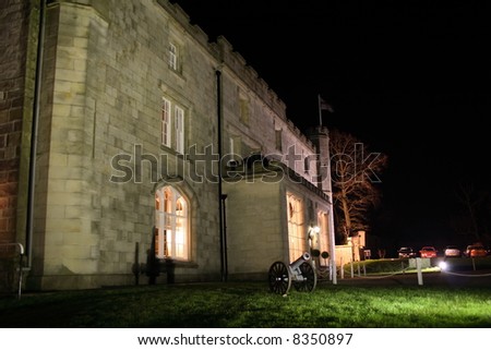 old stately home lit up at night and situated in the english countryside