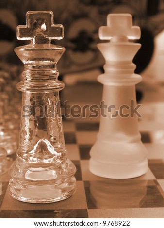 glass chess set game with a engraved glass playing board coloured sepia the clear king  is the focal point