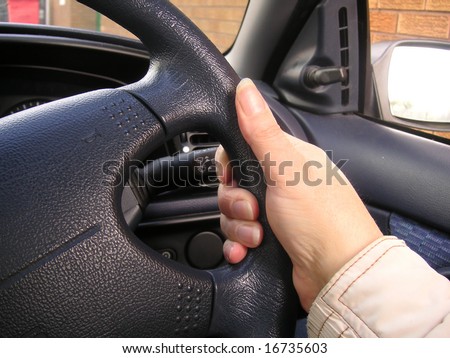 hand holding a steering wheel when driving