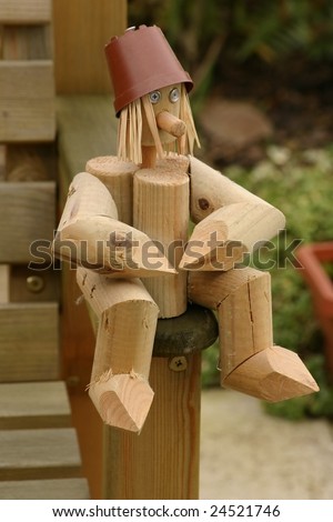little man made from wooden logs with straw for hair