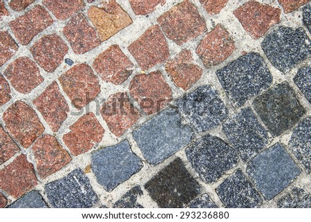 Many-coloured stone background on the basis of natural material. Sidewalk, paved with granite elements.