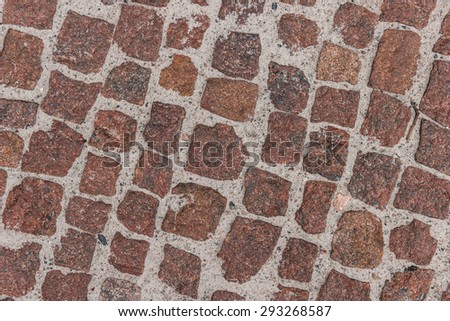 Coloured stone background on the basis of natural material. Sidewalk, paved with granite elements.