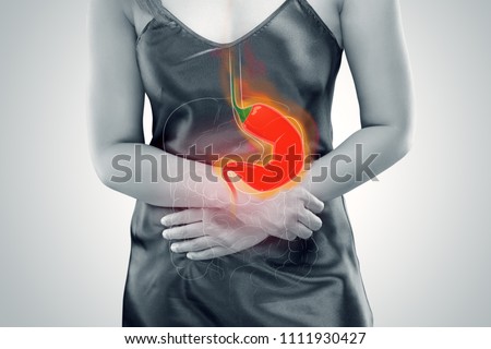 Woman Suffering From Acid Reflux Or Heartburn - Against gray background