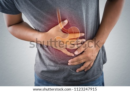Acid reflux or Heartburn, The photo of stomach and internal organs is on the men\'s body against gray background, Stomach ache, Bad health, Male anatomy concept.