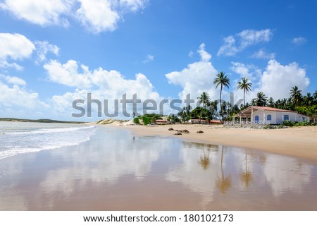 Beach at low tide with sand dunes and house, Pititinga, Natal (Brazil)