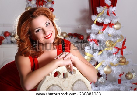 Christmas and New Year. Woman in the beautiful interior with a Xmas tree