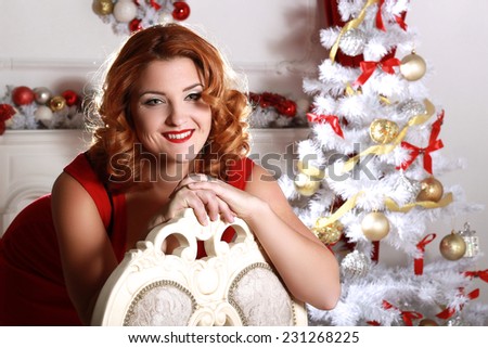 Christmas and New Year. Woman in the beautiful interior with a Xmas tree