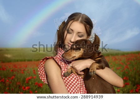 Girl dressed up as Dorothy from Oz. poppy field. With the dog on the hands and the rainbow