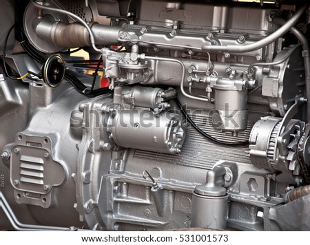 Silver colored pipes and parts on a tractor engine