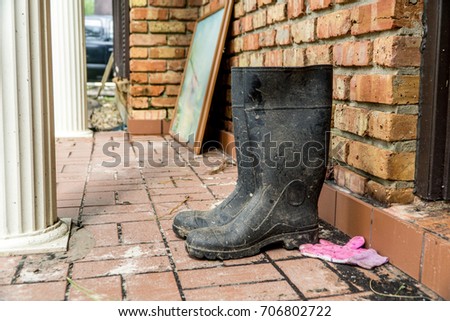 Water soaked rain boots next to a flooded home after Hurricane Harvey