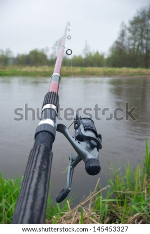 Fishing pole, green grass and water