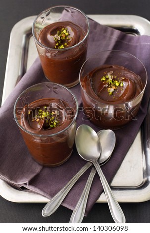three servings of chocolate avocado pudding on a silver tray