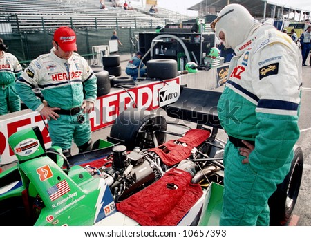 Car racing crew look at the engine. Editorial use only.