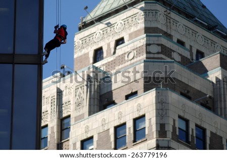VANCOUVER, CANADA - SEPTEMBER 10, 2014: People climb down office building during Easter Seals Drop Zone fundraiser to benefit children with disabilities in Vancouver, Canada, on September 10, 2013.
