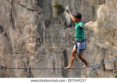 SQUAMISH, BC, CANADA - JUNE 13, 2015: An adventure athlete walks the highline rigged across the gully of the Stawamus Chief in Squamish, BC, Canada, June 13, 2015.