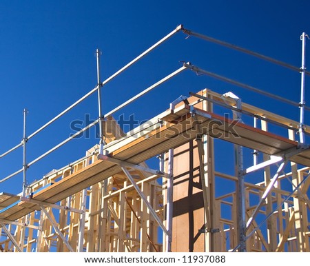 Detail of a house frame under construction with safety scaffolding