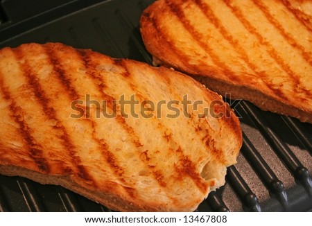 Grilled cheese sandwiches being cooked on electric grill