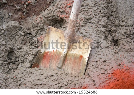 Shovel stuck in wet concrete for a slab under construction
