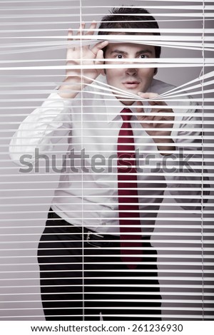 Man Watching through window blinds