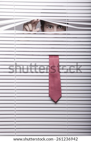 Man Watching through window blinds