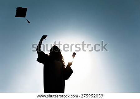 Graduate students tossing up hats over blue sky