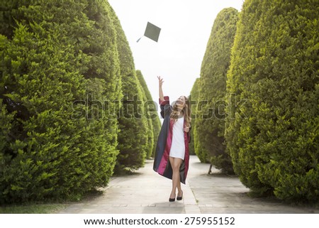 Education theme of happy graduate student girl outdoors