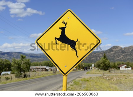 Deer Crossing warning sign on road