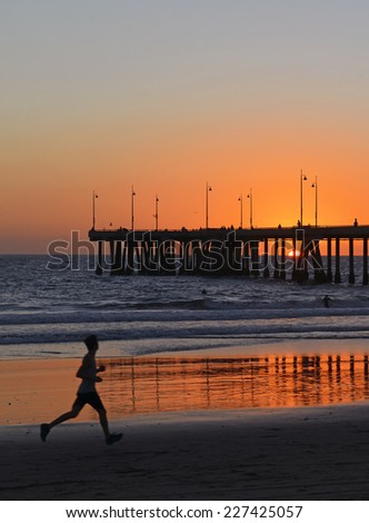 Silhouette of Jogger, Running on sand at Sunset on Venice Beach near Los Angeles, California, USA