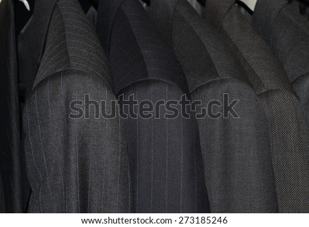 Row of mens suits on hangers in closet