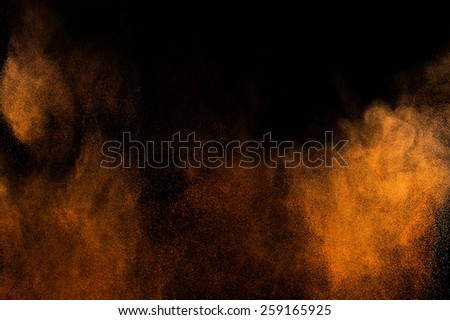 Abstract orange paint Holi. Abstract orange powder explosion on black background.