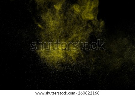 Abstract yellow and gold paint Holi. Abstract yellow and gold powder explosion on black background.