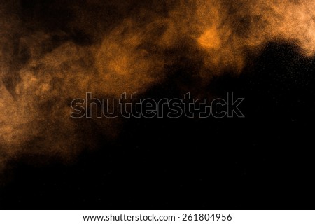Abstract orange paint Holi. Abstract orange powder explosion on black background.