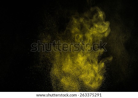 Abstract yellow and gold  paint Holi. Abstract yellow and gold powder explosion on black background.