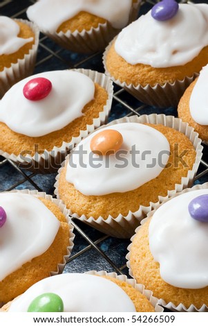 اروع تشكيلة لمحبي الكاب كيك Stock-photo-iced-buns-on-a-tray-with-coloured-sweet-tops-54266509