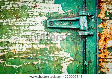 Texture metal door with hinge detail. Rusty door with cracked paint. Green painted door.