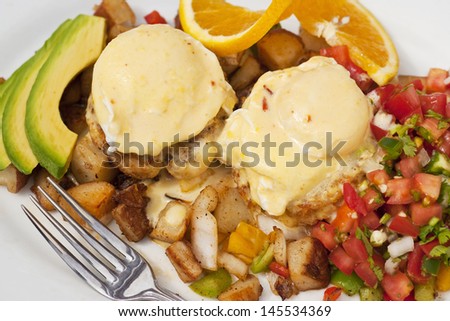 poached eggs over Dungeness crab cakes with chipotle Hollandaise sauce on a bed of roasted potatoes