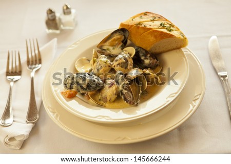 steamed mussels and clams in garlic cream sauce served with bread