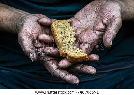 Dirty hands homeless poor man with piece of bread in modern capitalism society
