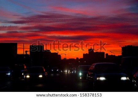 Sunset in the city. Roofs of houses and cars