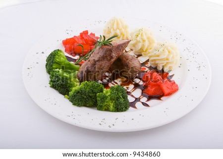 Plate with cabbage broccoli, pineapples in red wine, sauce, beef and a rosemary