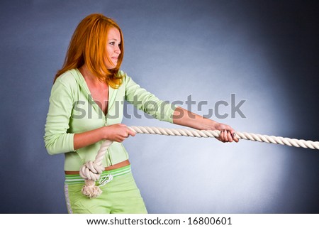 The young woman in a sports suit pulls a rope